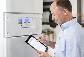 Mann mit Tablet in der Hand vor neuer Heizung