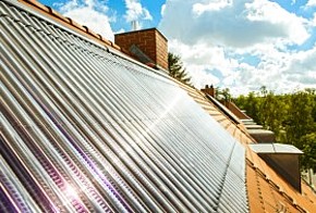 Röhrenkollektor auf Hausdach mit Sonnenreflektion