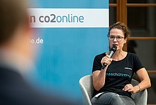 co2online-Geschäftsführerin Tanja Loitz mit Mikro auf dem Podium des Online-Klimatalks